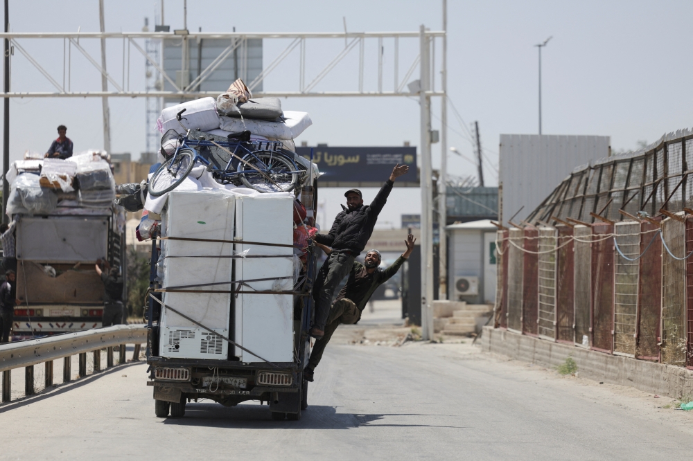 A truck transporting families drive through Bab al-Salameh border crossing, Syria. — Reuters