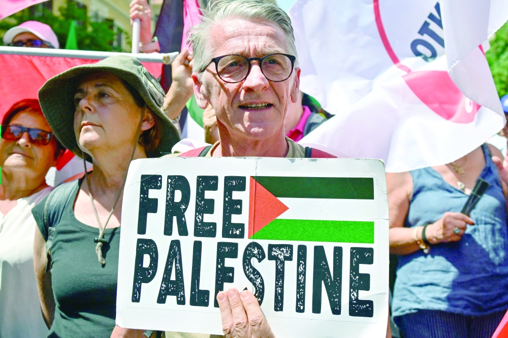 A man holds a placard during a demonstration in support of Palestinians in Gaza, in Rome. — AFP