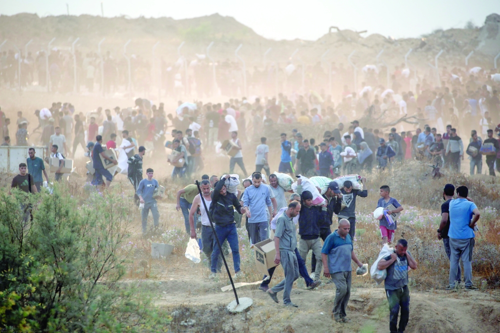 People carry relief supplies from the Gaza Humanitarian Foundation (GHF), in Gaza. — AFP