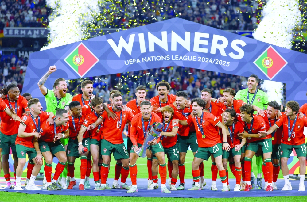 Cristiano Ronaldo lifts the trophy as he celebrates with teammates. — Reuters