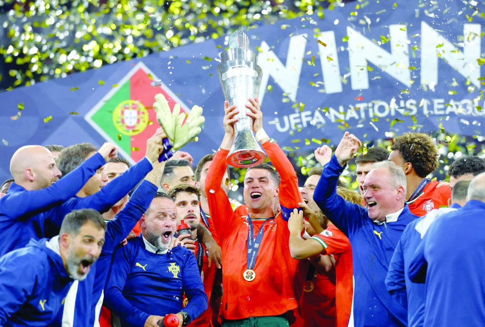 Portugal's Cristiano Ronaldo lifts the trophy as he celebrates with teammates. — Reuters