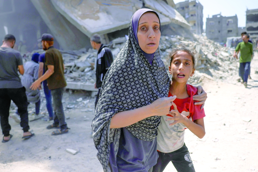 Palestinians react following an Israeli strike, in the Saftawi neighbourhood, west of Jabalia. — AFP