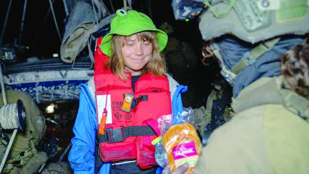 An Israeli solider passes a bun to Greta Thunberg onboard 'Madleen' on Monday. — Reuters