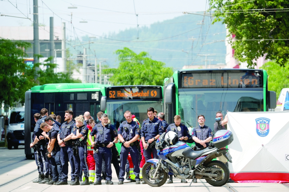 Police officers stand as children are evacuated from the school, in Graz. — Reuters