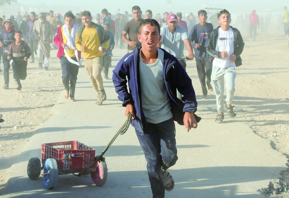 Palestinians rush to collect aid supplies, in Khan Younis, in the southern Gaza Strip. — Reuters