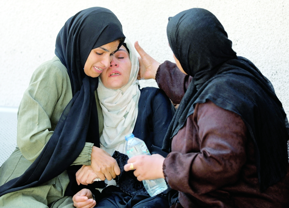 Mourners react during the funeral of Palestinians killed by Israeli fire in Gaza City on Tuesday. — Reuters