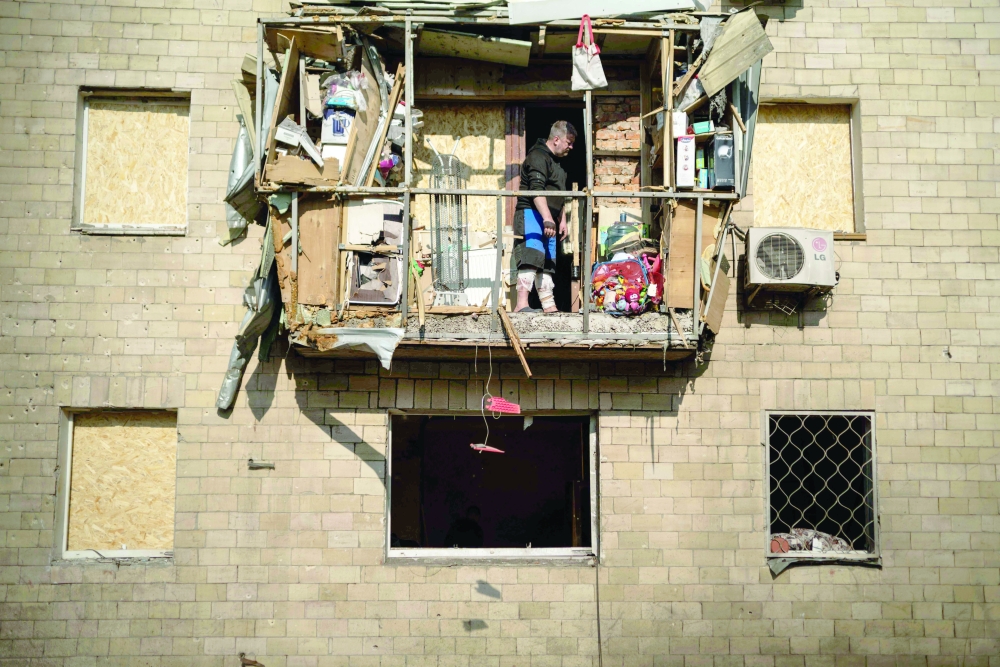 A man stands on a damaged balcony on Ukraine's northeastern city of Kharkiv. — AFP