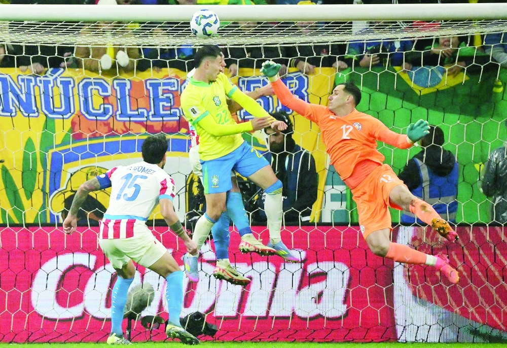 Brazil's forward 22 Gabriel Martinelli jumps to head the ball past Paraguay's goalkeeper 12 Roberto Fernandez and defender 15 Gustavo Gَmez. — Reuters