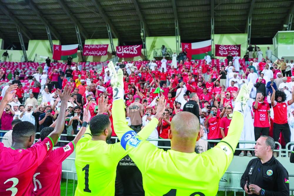 Oman players celebrate with the fans