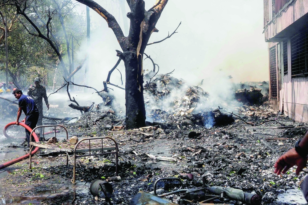 Firefighters work at the site where Air India Flight 171 crashed. — AFP