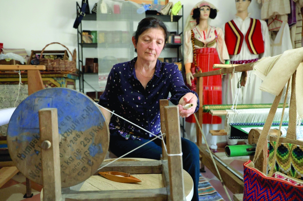 Mimoza Pjetraj prepares silk threads before installing them on her loom in her workshop in the village of Dajc, in the Zadrima region. — AFP