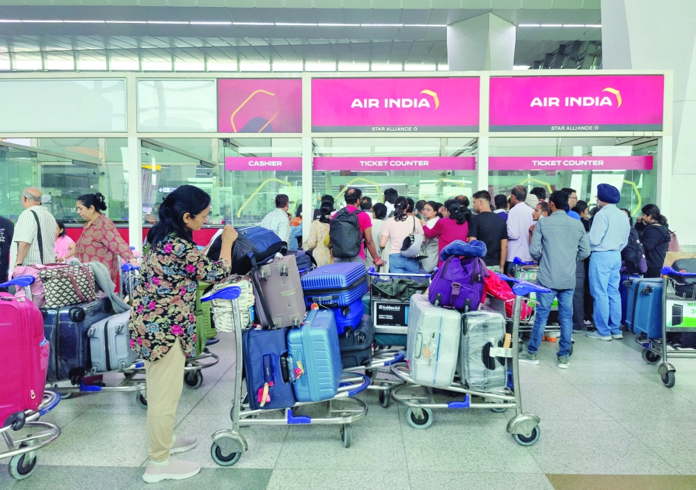 Passengers gather in front of the ticket counter of Air India airlines, as the flights got delayed and cancelled after airlines divert flights following Israeli strikes in Iran, in Delhi, India. — Reuters