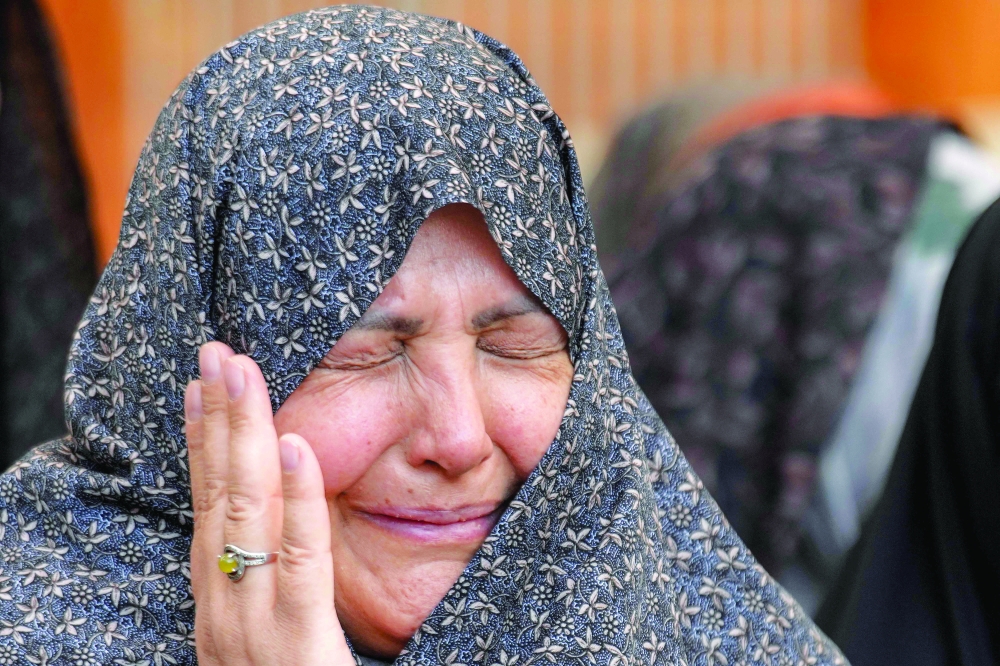 A Muslim worshipper reacts as she prays with other Iranian pilgrims visiting the Imam Ali Shrine in Iraq's central holy shrine city of Najaf on Friday, in the wake of Israel's strikes on Iran earlier in the day. — AFP
