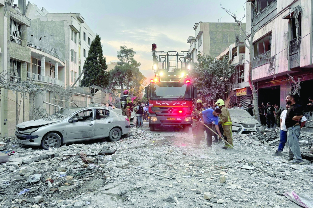 First-responders gather outside after an Israeli strike in Tehran on Friday. — AFP