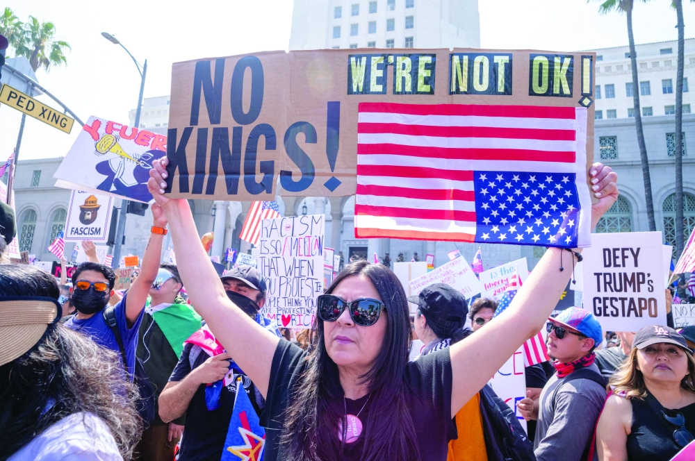 Demonstrators hold signs as they protest the Trump administration during the "No Kings" rally in downtown Los Angeles, California on Saturday, on the same day as President Trump's military parade in Washington, DC. — AFP