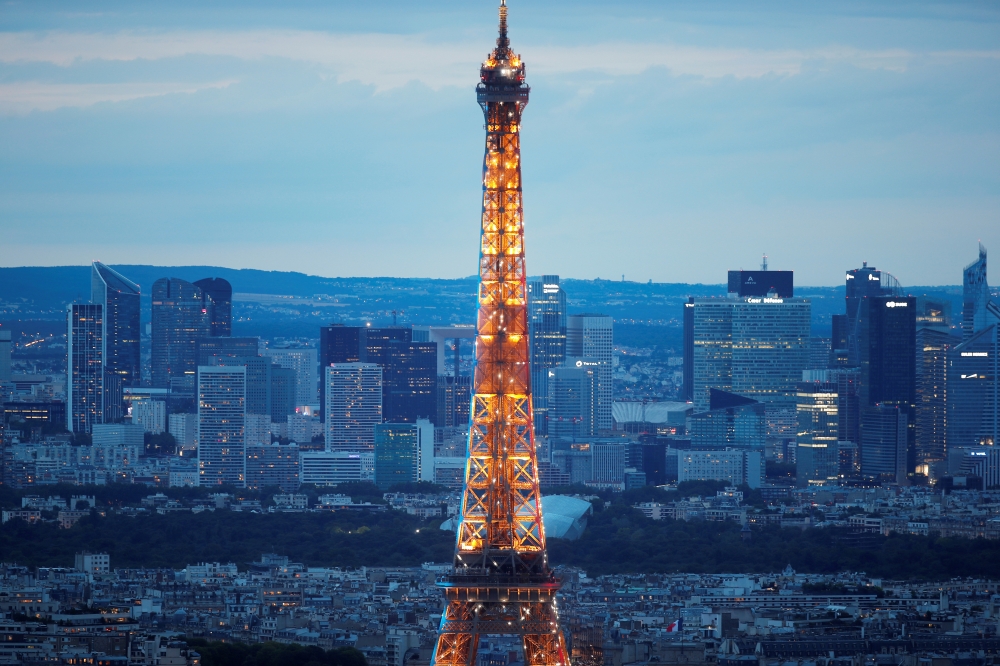 The skyline of La Defense business district is seen behind the Eiffel tower in Paris, France. — Reuters