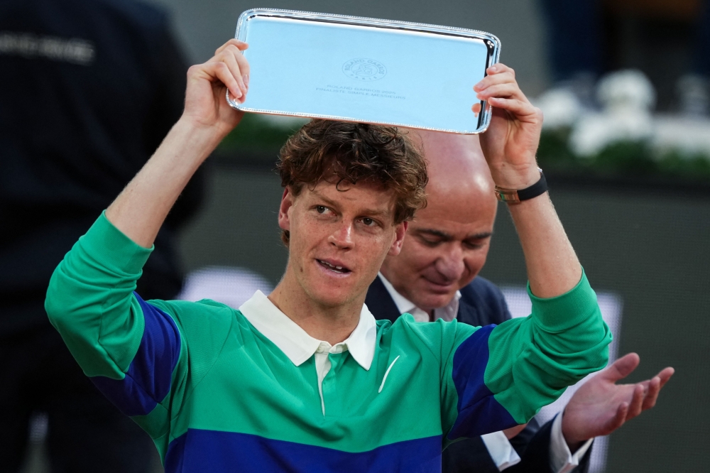Second-placed Italy's Jannik Sinner holds his trophy next to former US tennis player Andre Agassi at the Roland-Garros. — AFP