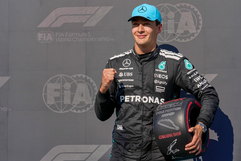 Mercedes' British driver George Russell gestures after winning the pole position. — AFP