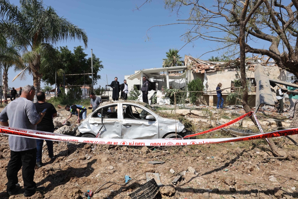 People check the damage at the site of an Iranian missile strike, in southern Israel. — AFP