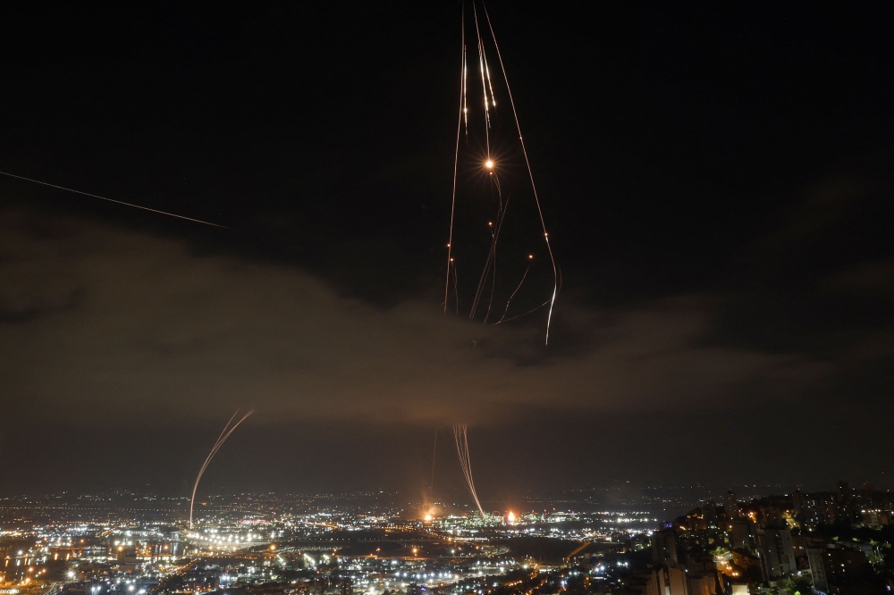 Israeli air defence systems are activated to intercept Iranian missiles over Haifa. — AFP