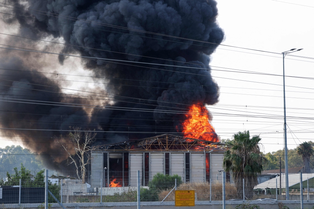 Smoke billows from a fire in a building in Herzliya near Tel Aviv following a fresh barrage of Iranian rockets on June 17