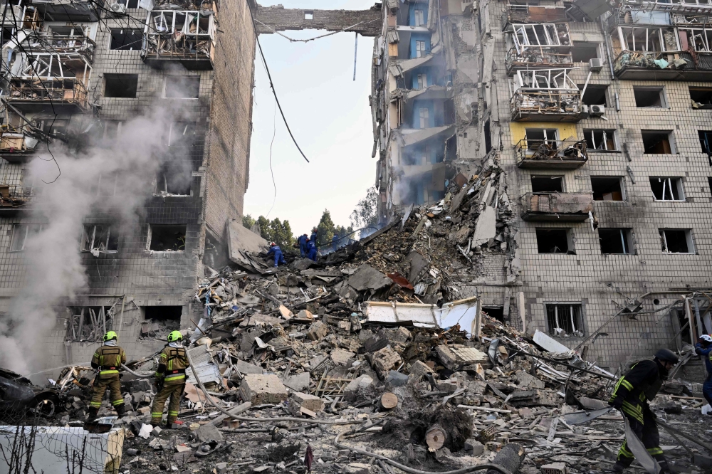 Rescuers conduct a search and rescue work in a heavily damaged building, in Kyiv. — AFP