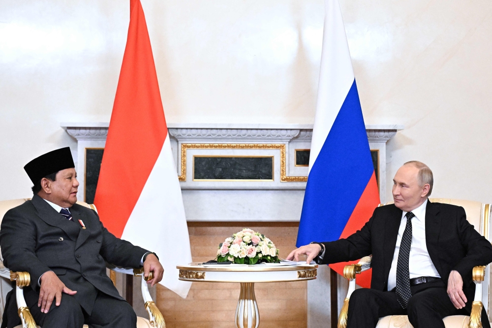 Russia's President Vladimir Putin (R) speaks with his Indonesian counterpart Prabowo Subianto in Saint Peterburg. — AFP