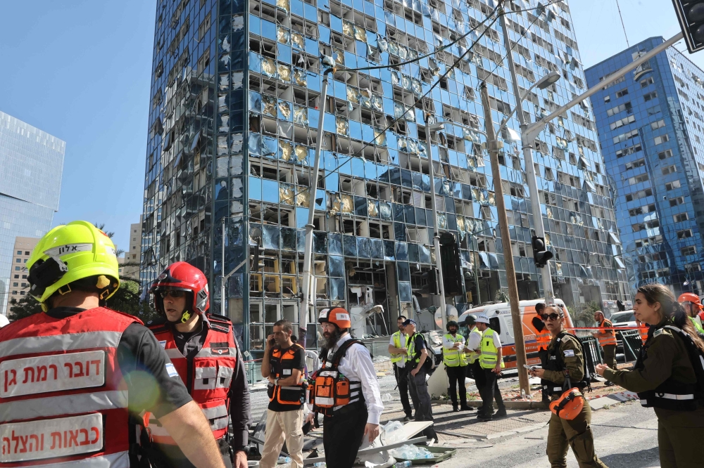 Israeli emergency services work at the site of an Iranian missile attack, near Tel Aviv. — AFP