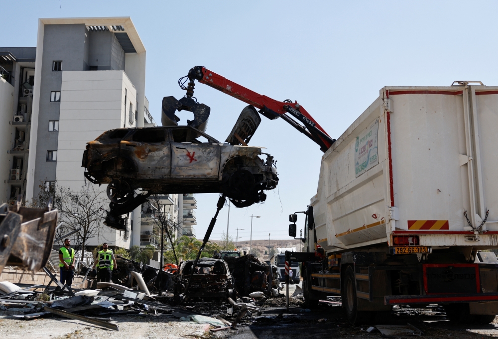 A crane lifts a destroyed car at an impact site following Iran's missile strike on Israel, in Be'er Sheva, Israel. — Reuters