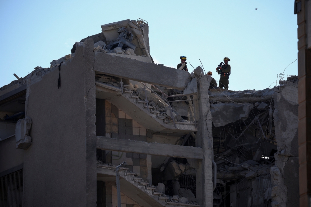 Emergency personnel work at an impact site following Iran's missile strike on Israel, amidst the Iran-Israel conflict, in Haifa, Israel. — Reuters
