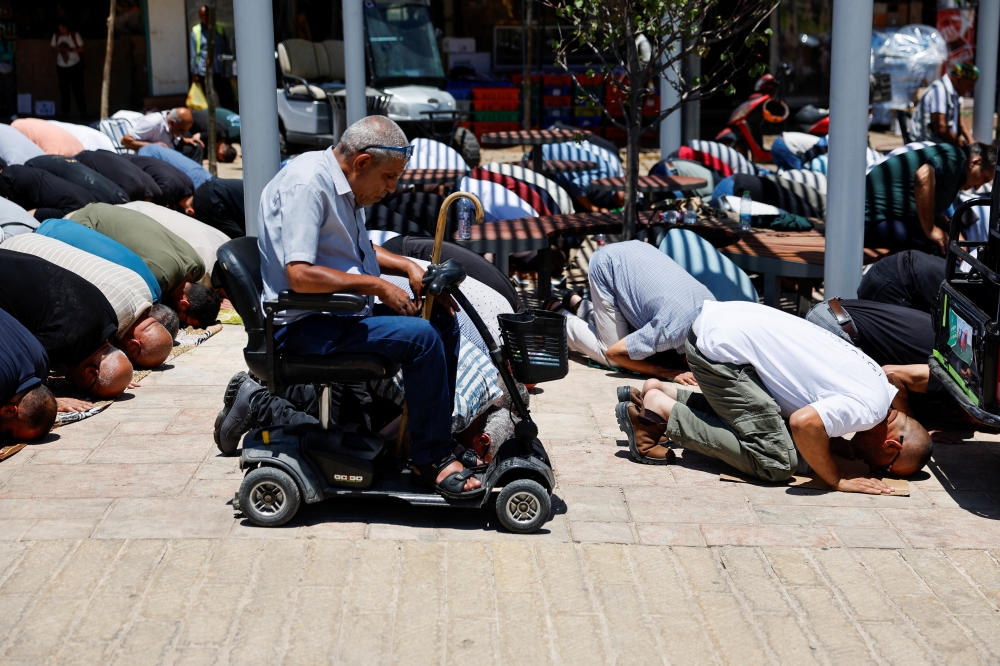 Worshippers attend Friday prayers outside Jerusalem's Old City, as access to the Al Aqsa mosque is blocked, in Jerusalem. — Reuters