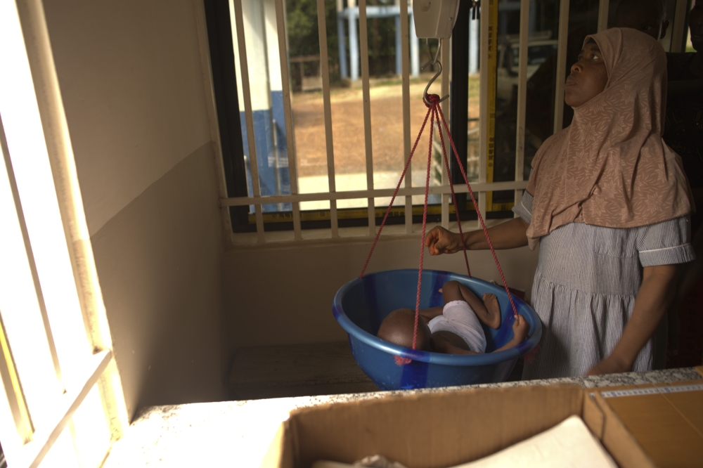 A health worker weighs a baby at a clinic in Bombali District, Sierra Leone. NYT file photo