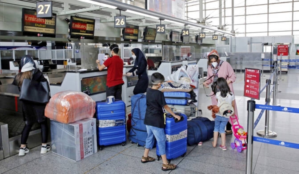 Outbound passengers arrive with their luggage at the Emirates check-in counter at the Iranian capital Tehran's Imam Khomeini International Airport.- AFP File   
