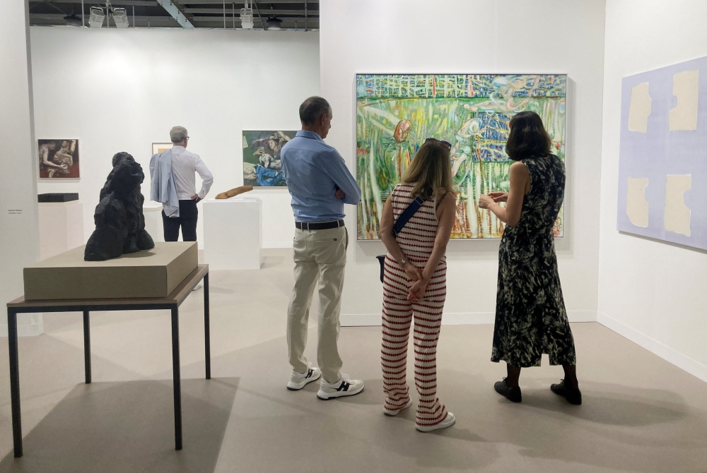 Visitors look at artworks displayed at Art Basel, in Basel, Switzerland, June 17, 2025. 