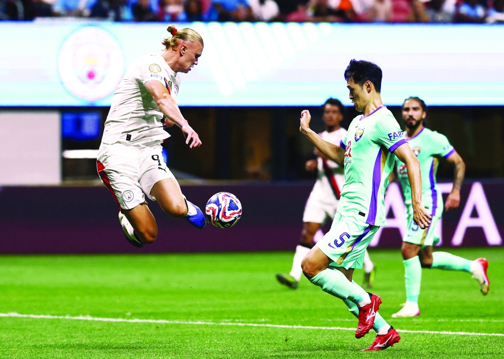 Manchester City's Erling Haaland in action with Al Ain's Park Yong-woo. — Reuters