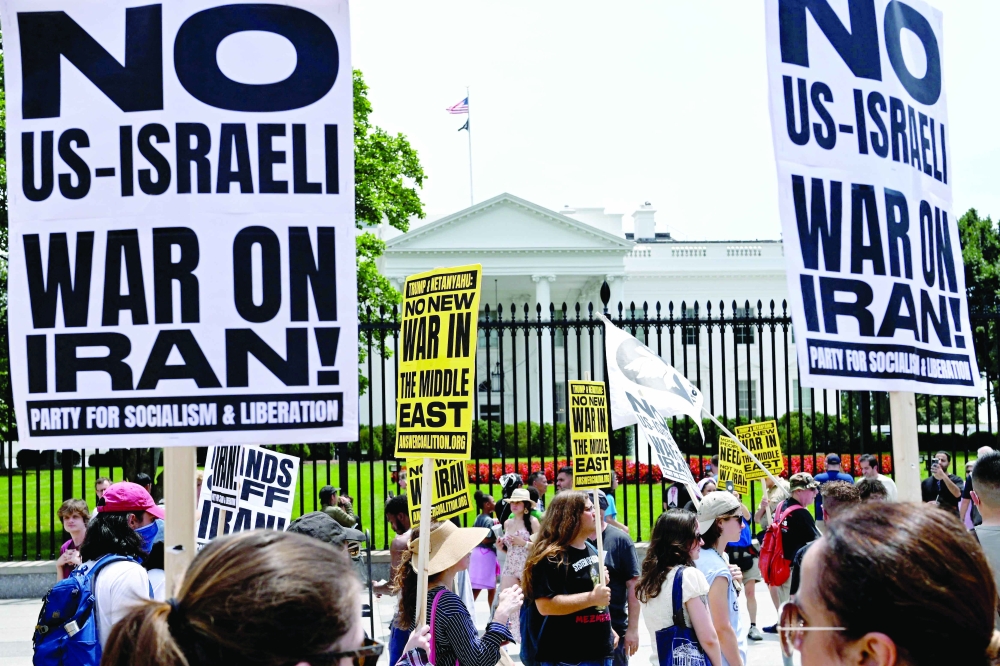People hold signs as they demonstrate in front of the White House in Washington, DC. — AFP