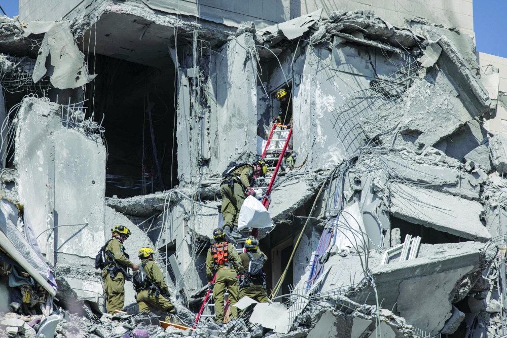 Israeli emergency services search for casualties in the rubble of a building, in Beersheba. — AFP