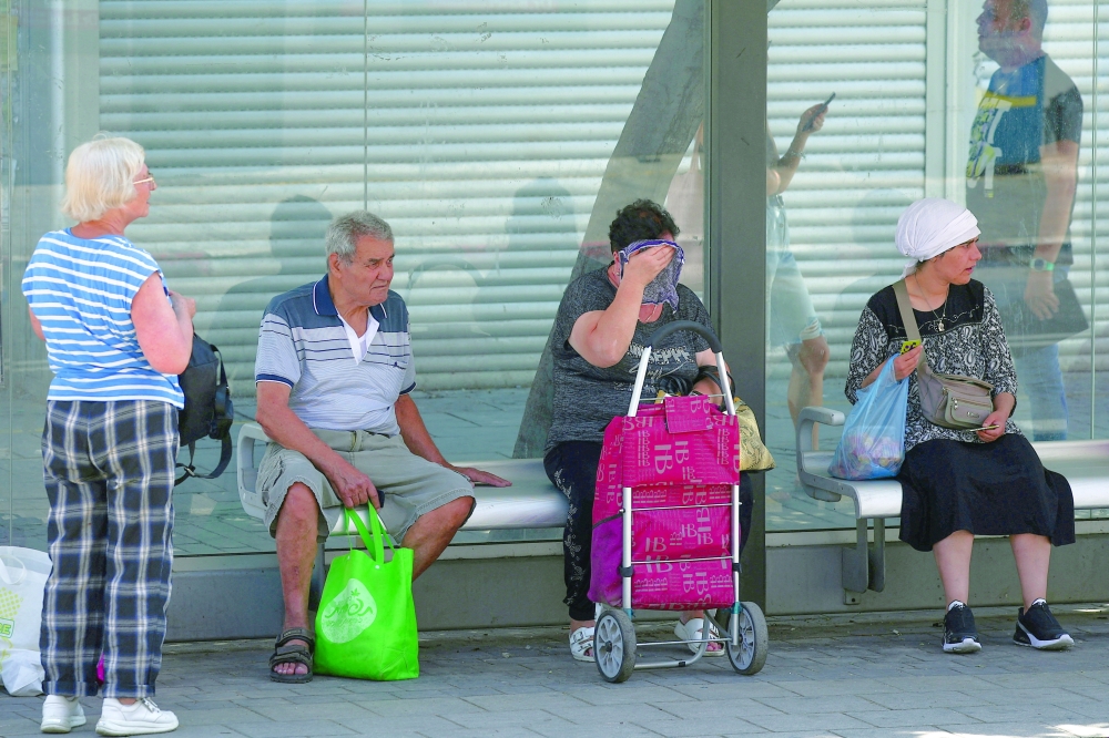 People wait at a buss station, after US President Donald Trump announced a ceasefire, in Haifa. — Reuters 