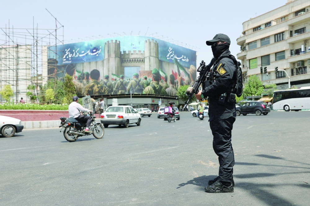 A security guard stands on a street, during early hours of ceasefire, in Tehran. — Reuters