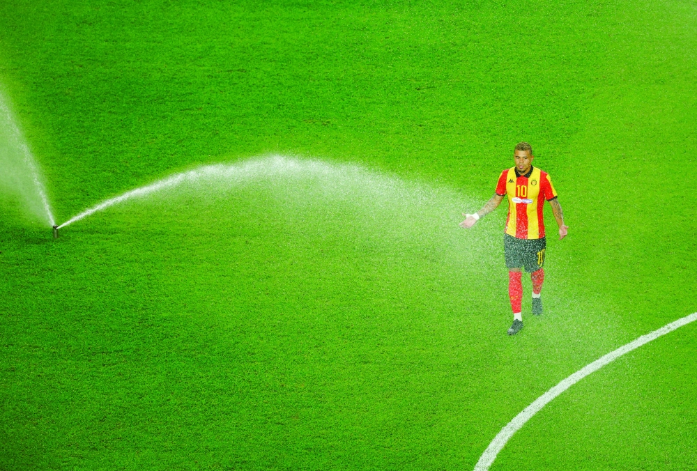 Esperance Sportive de Tunis' Yan Sasse reacts as sprinklers come on during the second half hydration break. — Reuters