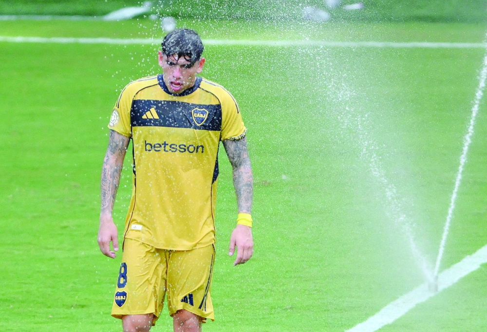 Boca Juniors' Carlos Palacios as sprinklers are used to cool down the players during a break in play. — Reuters 