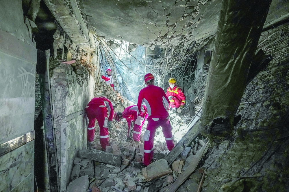 Rescuers sift through the rubble inside in the Evin prison complex in Tehran. — AFP