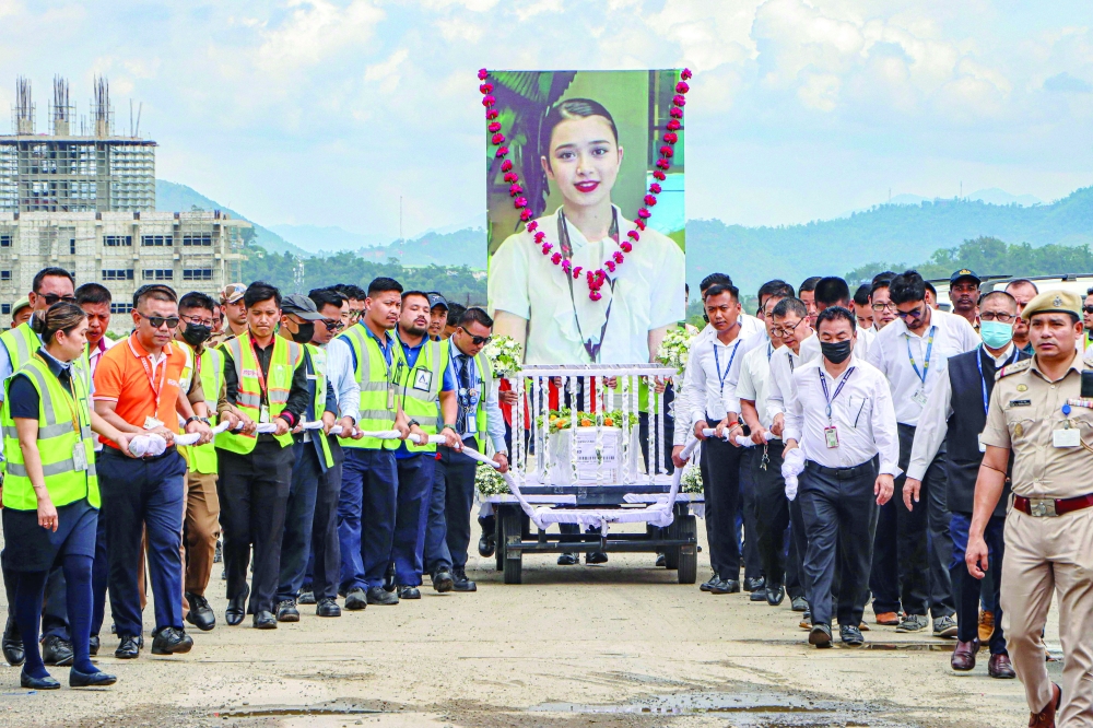 Aviation personnel carry the coffin of plane crash victim Kongbrailatpam Nganthoi Sharma, a cabin crew member of the Air India flight AI171, during her funeral ceremony at the international airport in Imphal last week. —  AFP