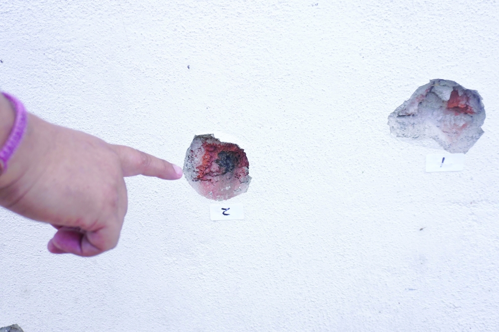 A person points at bullet holes on a wall after a shooting at the Barrio Nuevo neighbourhood in Irapuato, Guanajuato state, Mexico. — AFP