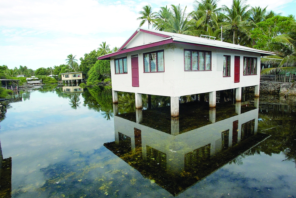 High tide floods a 'borrow pit' dug by US forces during World War II in order to build the airstrip on Funafuti Atoll, the 2.8 square kilometre home to nearly half of Tuvalu's entire population of 11,500. — AFP File