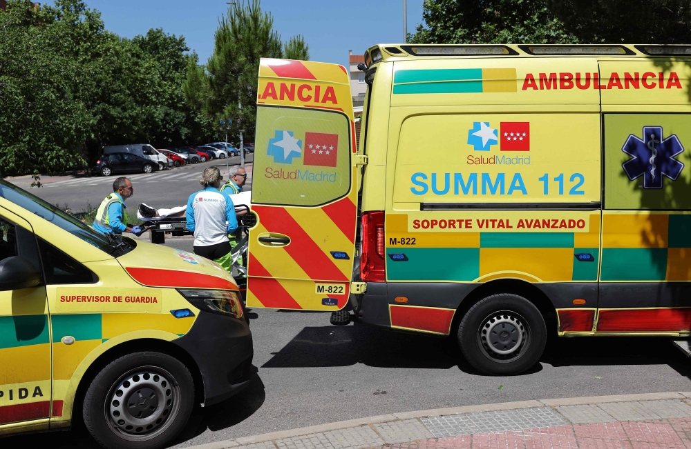 Paramedics from Madrid's medical emergency services SUMMA load a person on a stretcher, in Madrid. — AFP