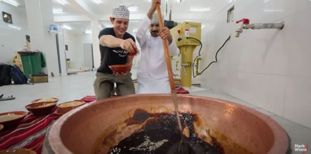 Mark Wiens helping to make Omani halwa in Nizwa