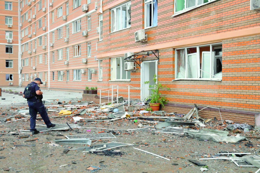 A policeman inspects debris at the bottom of a multi-storey residential building, which was damaged after a Russian drone attack in Odesa on Saturday. — AFP