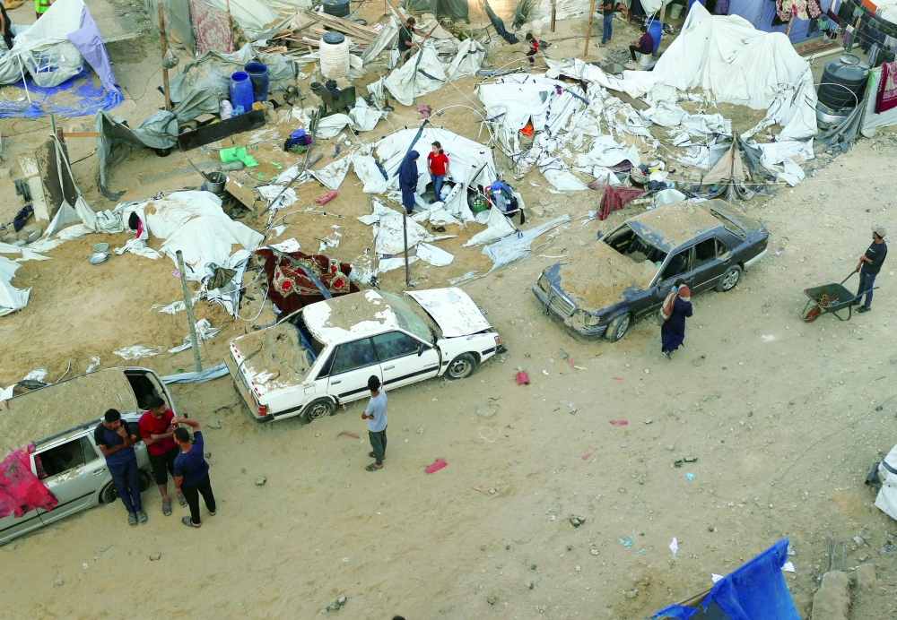 Palestinians gather at the site of a tent camp that was struck by an Israeli air strike in Gaza City on Saturday. — Reuters