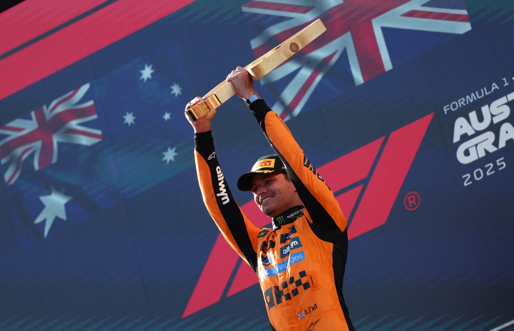 McLaren's Lando Norris celebrates on the podium with a trophy. — Reuters 